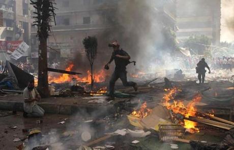 Reporters run for cover during clashes between Morsi supporters and police in Cairo.
